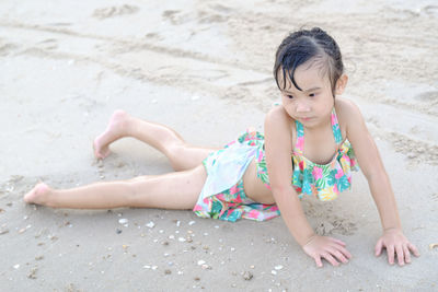 High angle view of girl playing on sand at beach