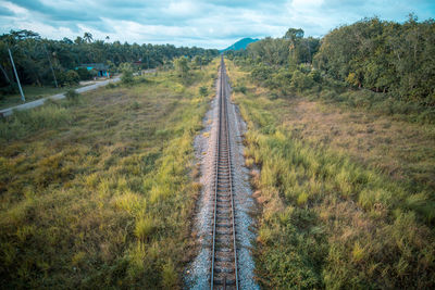 Road amidst field against sky