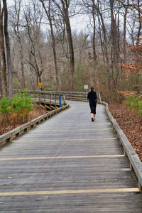 Rear view of man walking on footpath