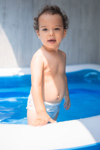 Portrait of shirtless boy swimming in pool