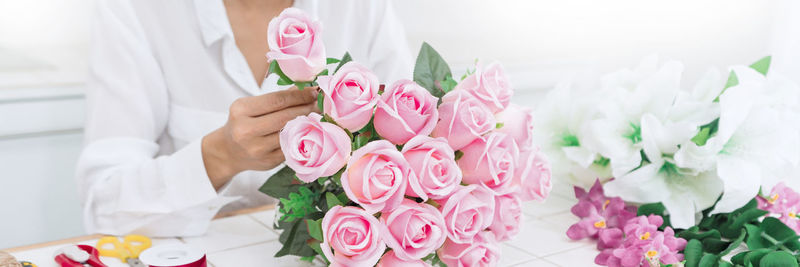 Midsection of woman making bouquet in flower shop