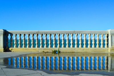 Metallic structure by building against clear blue sky