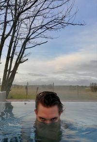 Man swimming in sea against sky