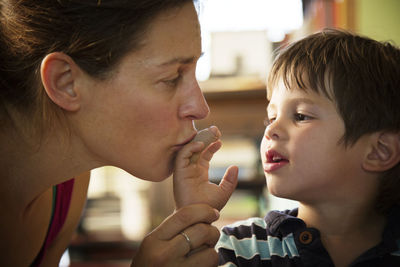 Mother kissing boy's finger