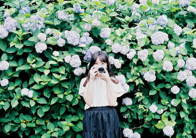 Woman standing by plants