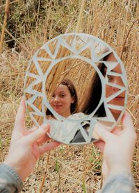 Portrait of woman holding camera on field