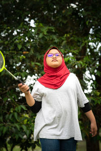 Young hijab asian girl with badminton racket at the park.