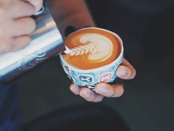 Close-up of hand holding coffee cup