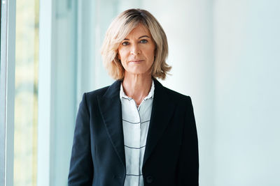 Businesswoman standing against wall