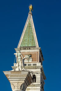 Low angle view of statue against blue sky