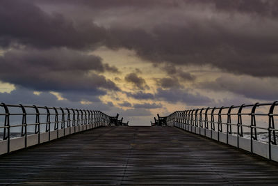 Footbridge over pier against sky during sunset