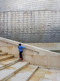 Rear view of man walking on steps