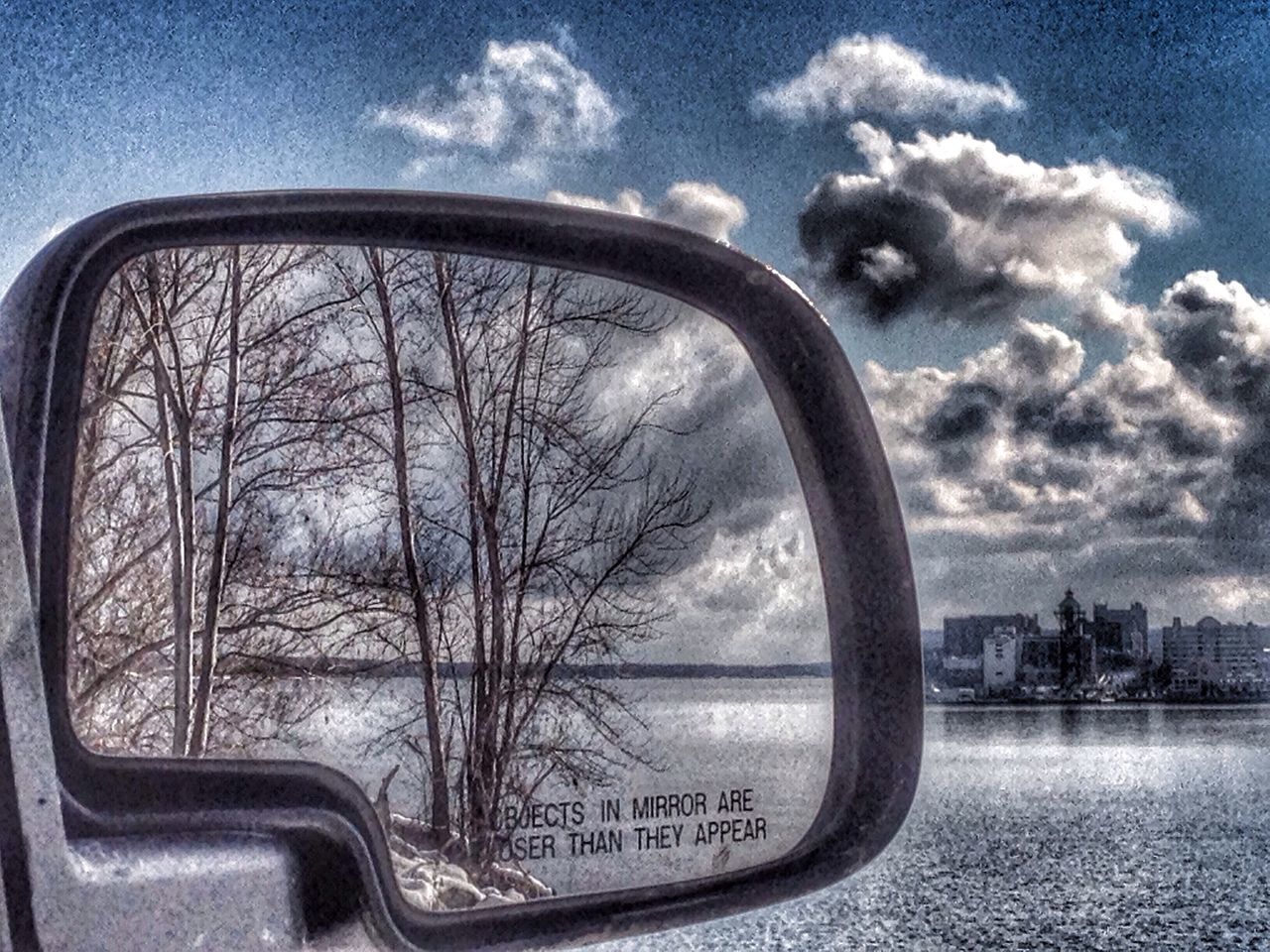 transportation, sky, mode of transport, cloud - sky, car, tree, reflection, land vehicle, side-view mirror, vehicle interior, water, cloud, bare tree, glass - material, road, transparent, street, no people, river, window