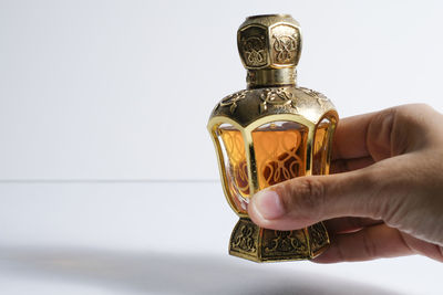 Close-up of person holding glass against white background