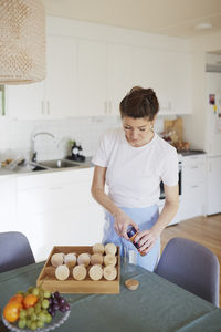 Woman in kitchen checking spices