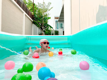 Full length of boy with toy in swimming pool