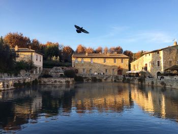 Lake by buildings against sky