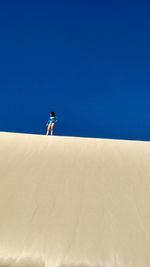 Woman standing on sand dune