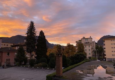 Buildings and trees against sky during sunset