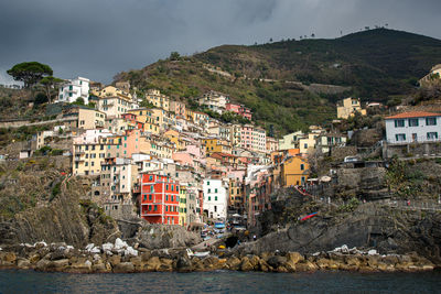 Aerial view of town of manarolla at cinque terre in italy  by sea against sky 