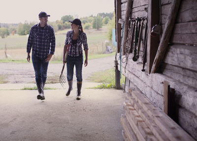 Full length of farming couple walking in barn