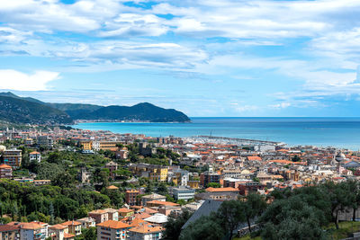 High angle view of townscape by sea against sky