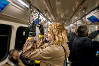 Rear view of women standing in train