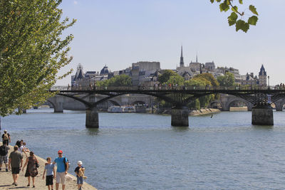 Bridge over river in city against clear sky