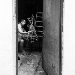 Side view of woman playing with open door