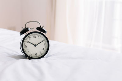 Close-up of clock on bed