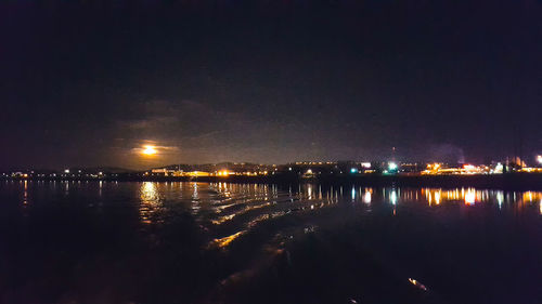 Illuminated city against sky at night