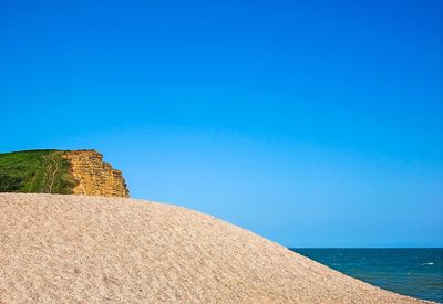 View of calm sea against clear blue sky