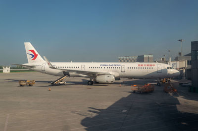 Airplane on airport runway against sky