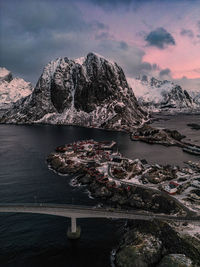 High angle view of townscape by sea against sky during sunset