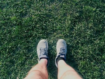 Low section of man standing on grass