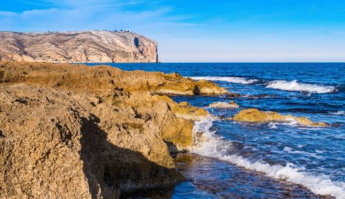 Scenic view of rocks in sea against sky