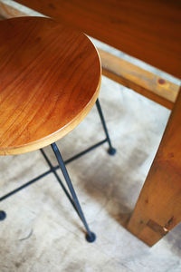 Wooden stool with black metal legs used in a cafe