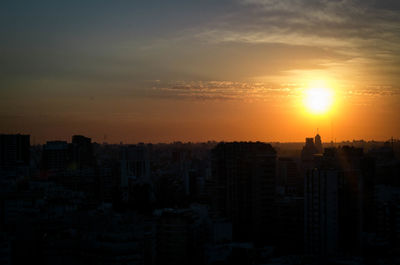 Silhouette buildings against sky during sunset