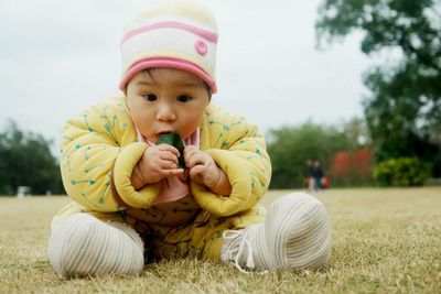 Portrait of cute baby girl chewing leaf