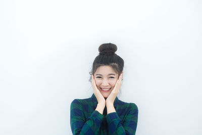 Portrait of smiling young woman over white background