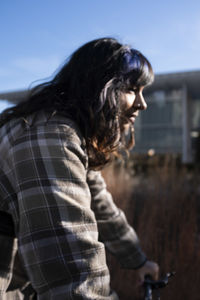 Side view of woman standing against sky