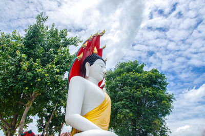 Low angle view of statue against trees against sky