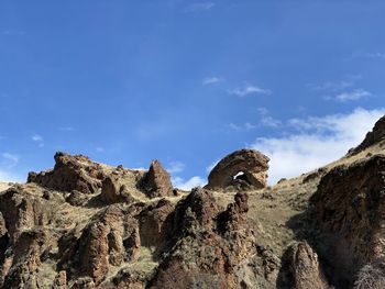 Low angle view of rock formations against sky