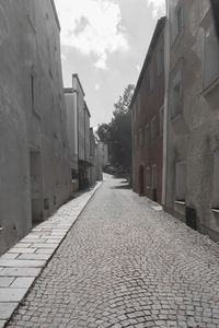 Cobblestone street amidst buildings in city