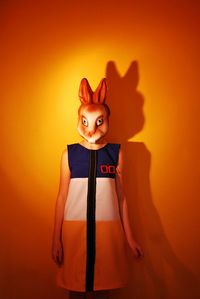 Woman with animal head over yellow background