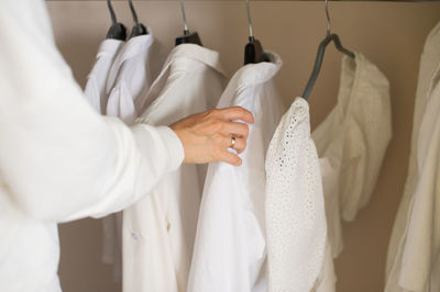 To fix with your hand white things in the closet on a hanger