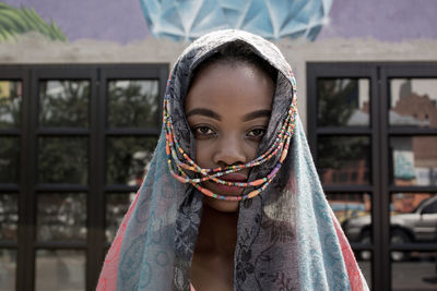 Close-up portrait of girl standing against blurred background