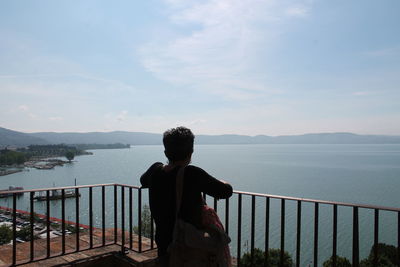 Rear view of woman looking at sea against sky