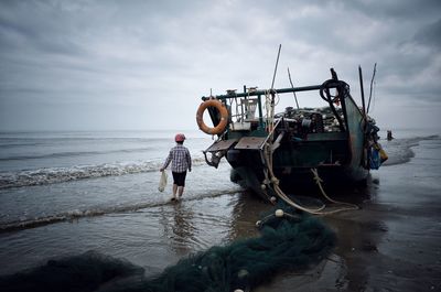 Man standing on beach against sky