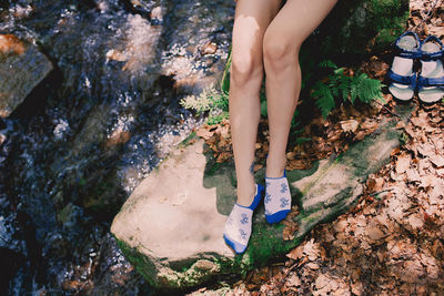 Low section of woman standing on rock